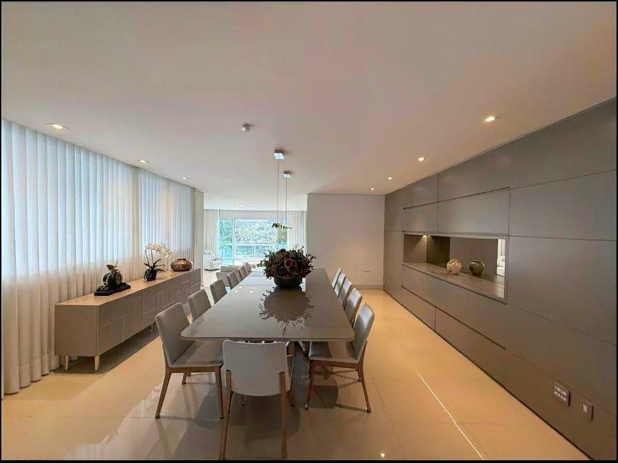 Ambiente social sofisticado com mesa ampla e acabamentos elegantes