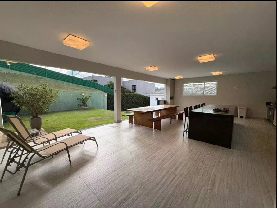 Espaço gourmet coberto com lounge e integração com o jardim