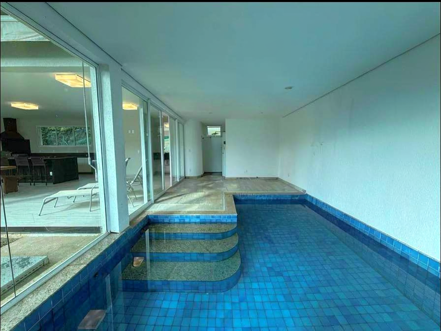 Piscina coberta da residência com integração visual à área gourmet